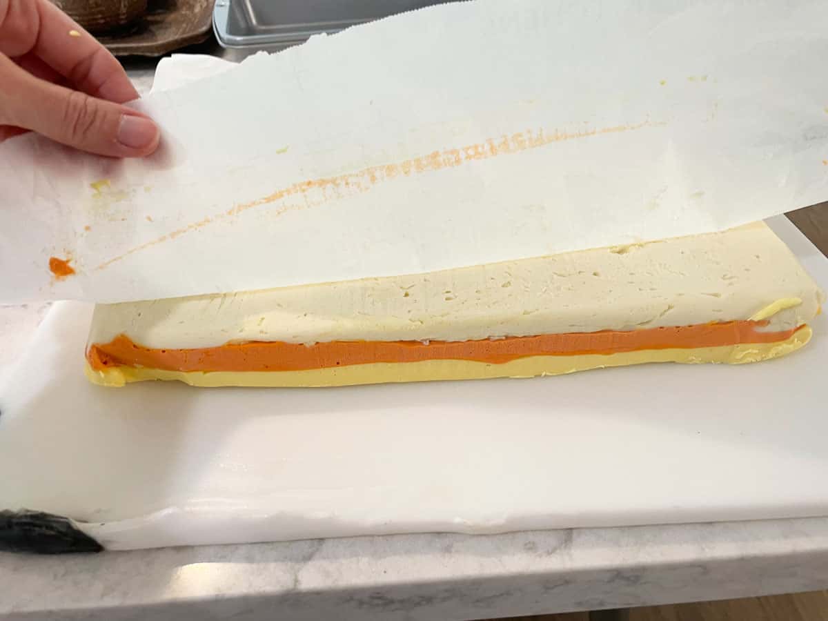 peeling parchment from top of candy corn fudge