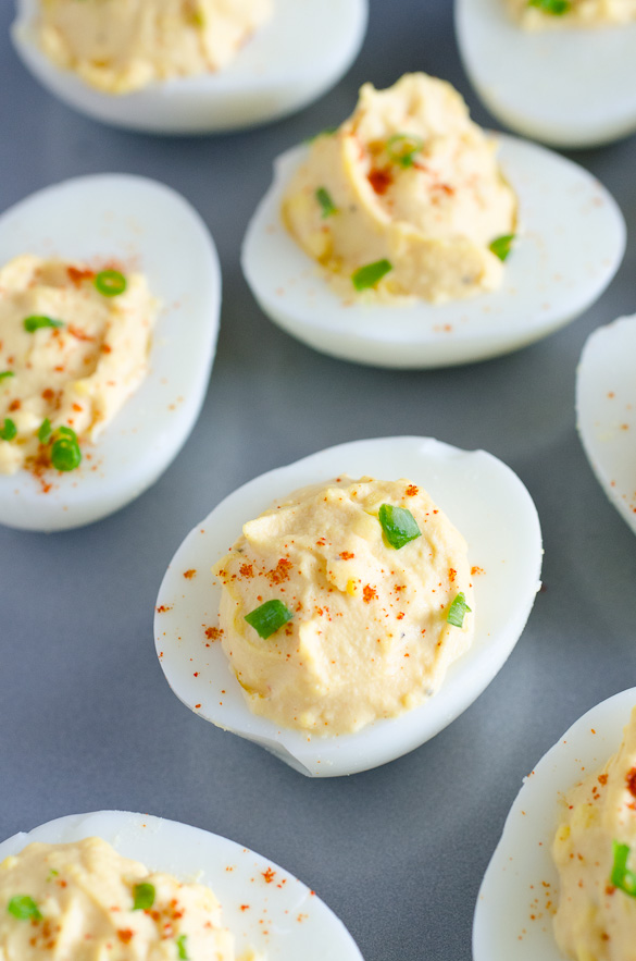plate of deviled eggs with paprika and chives