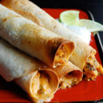 rolled taquitos stacked on a plate