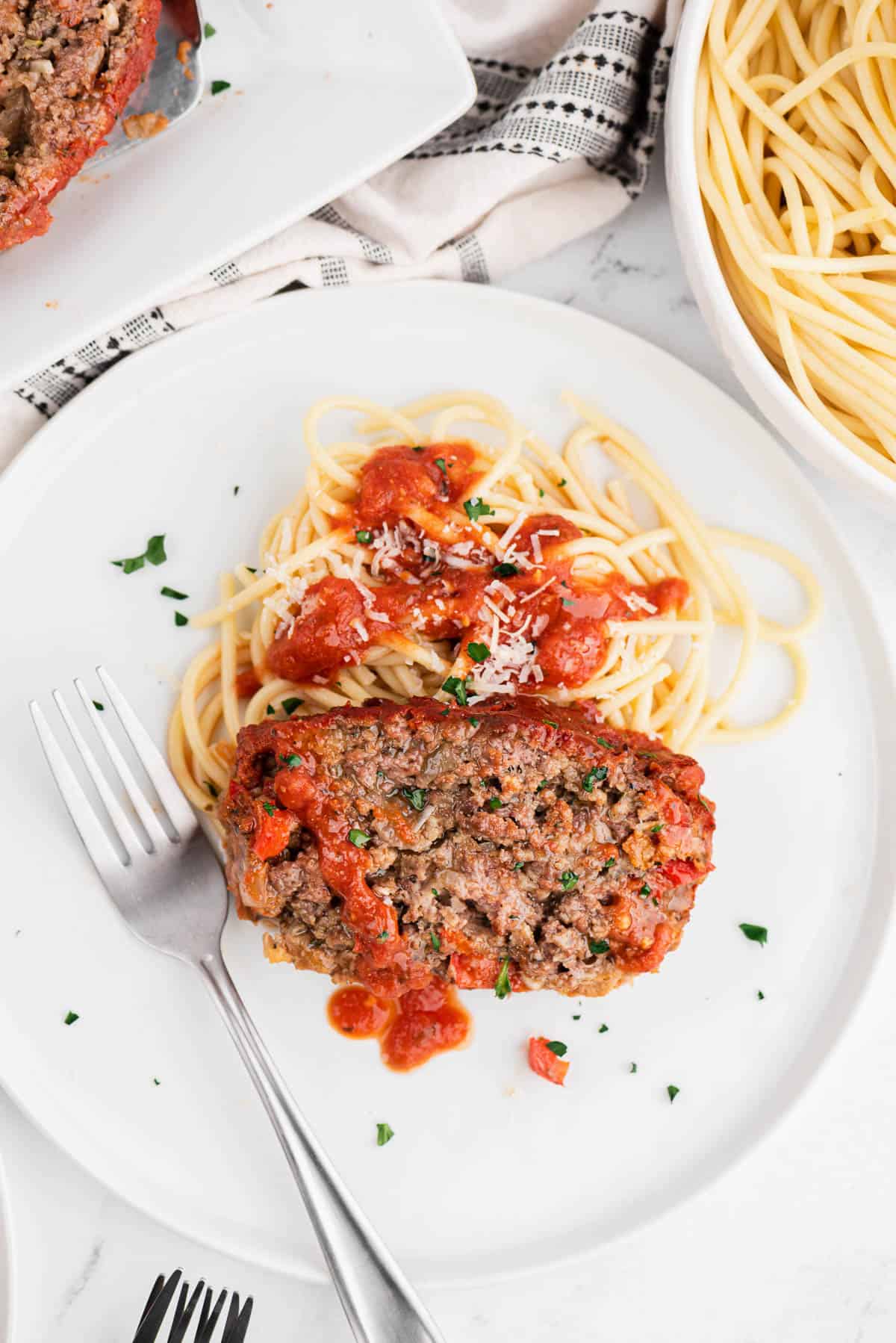 italian meatloaf on a plate with spaghetti