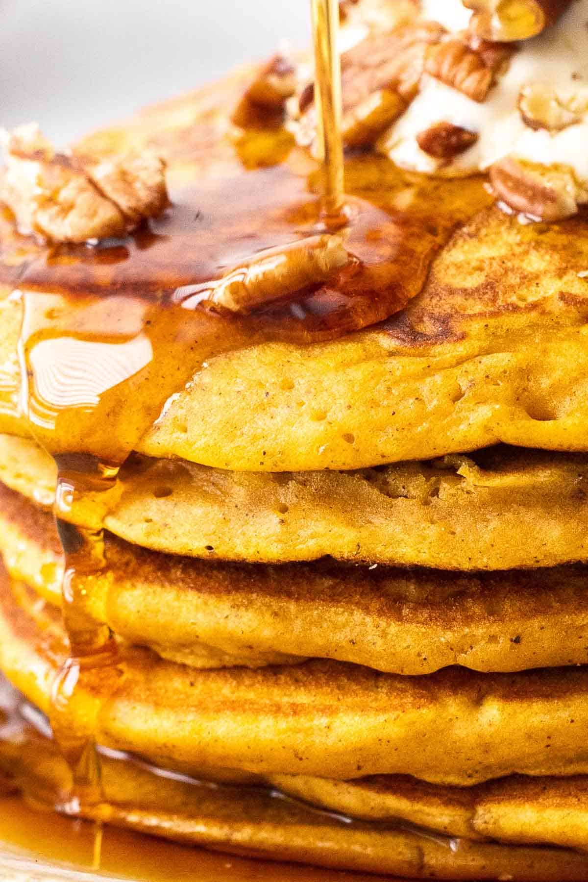 pumpkin spice pancakes in a stack drizzled with syrup