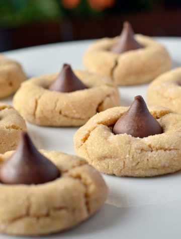 Classic Peanut Butter Blossoms are the epitome of the holidays! Peanut butter cookies rolled in sugar and topped with Hershey's Chocolate Kisses are the perfect cookies for a Christmas cookie exchange. Of course, you can enjoy these Peanut Butter Blossoms round!