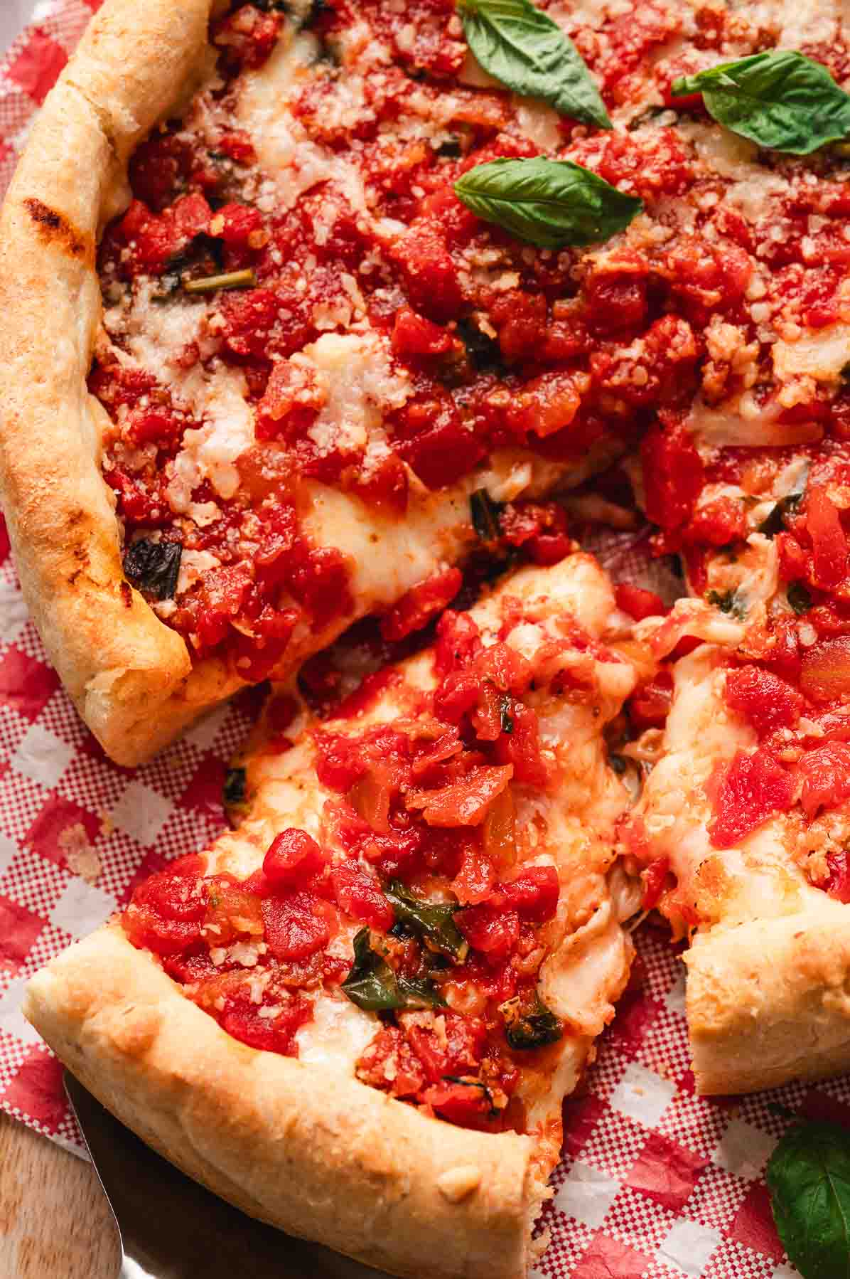 Slice of Chicago deep dish pizza showing thick crust, cheese layers, and rich tomato sauce