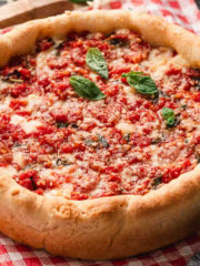 Homemade Chicago-style deep dish pizza baked in a cake pan with melted cheese and tomato sauce