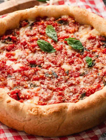 Homemade Chicago-style deep dish pizza baked in a cake pan with melted cheese and tomato sauce