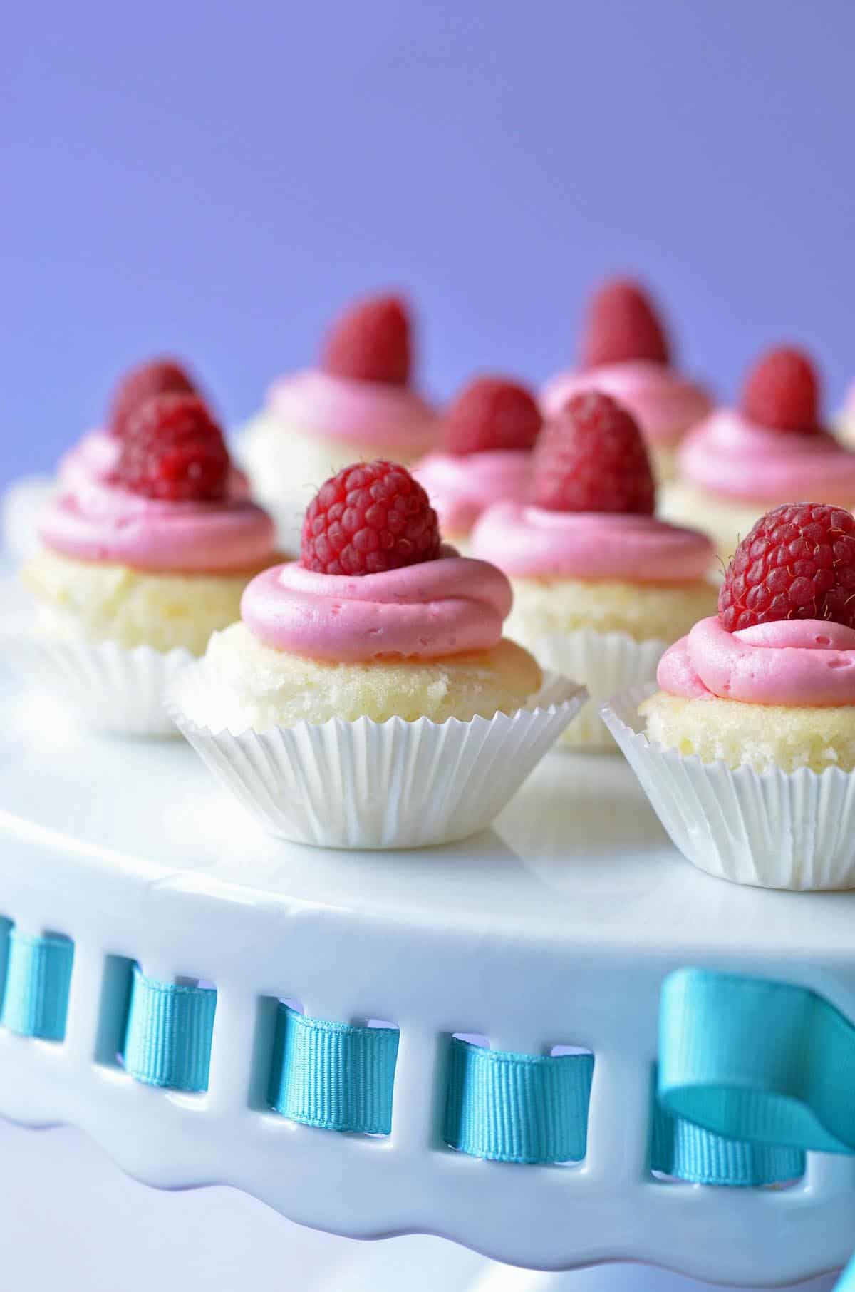 lemon cupcakes with raspberry frosting topped with raspberries
