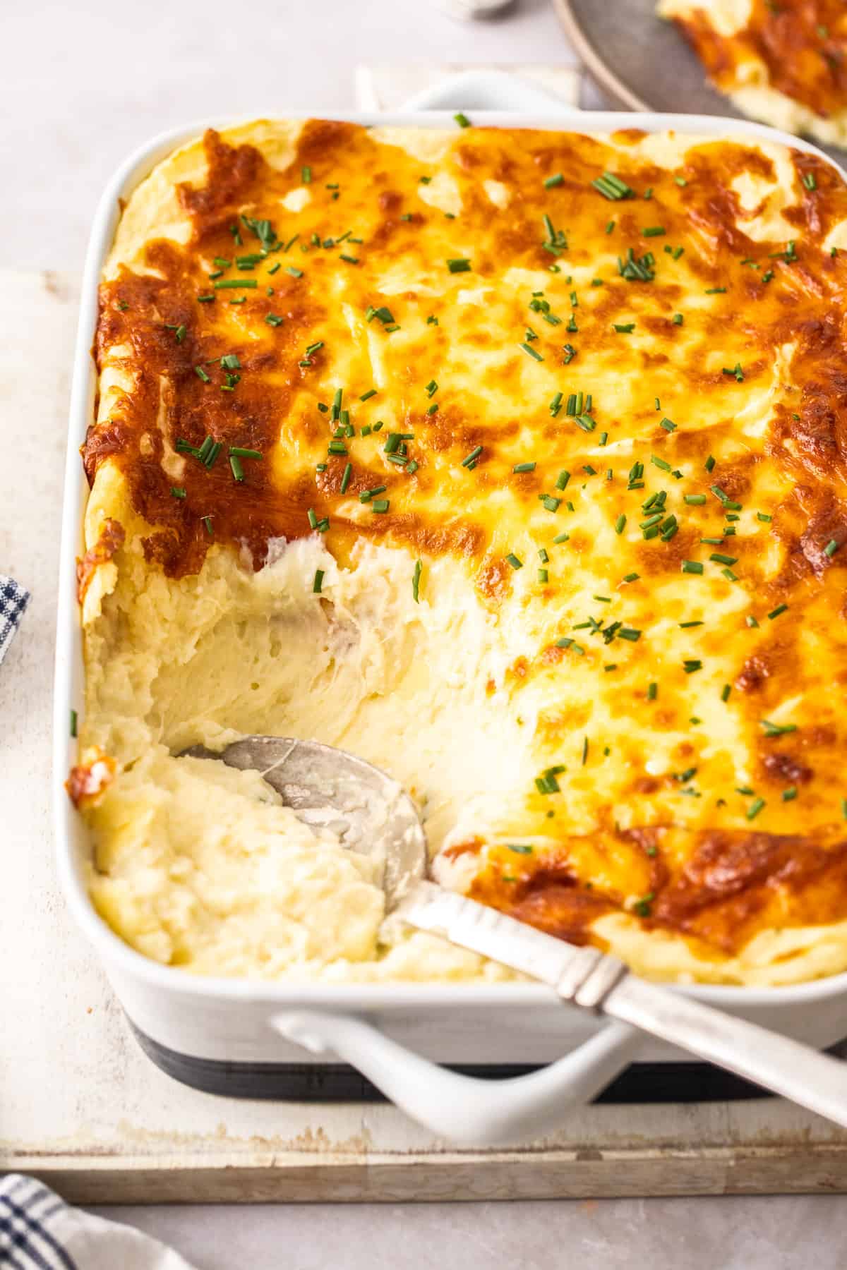 casserole dish of mashed potatoes with cheesy golden topping