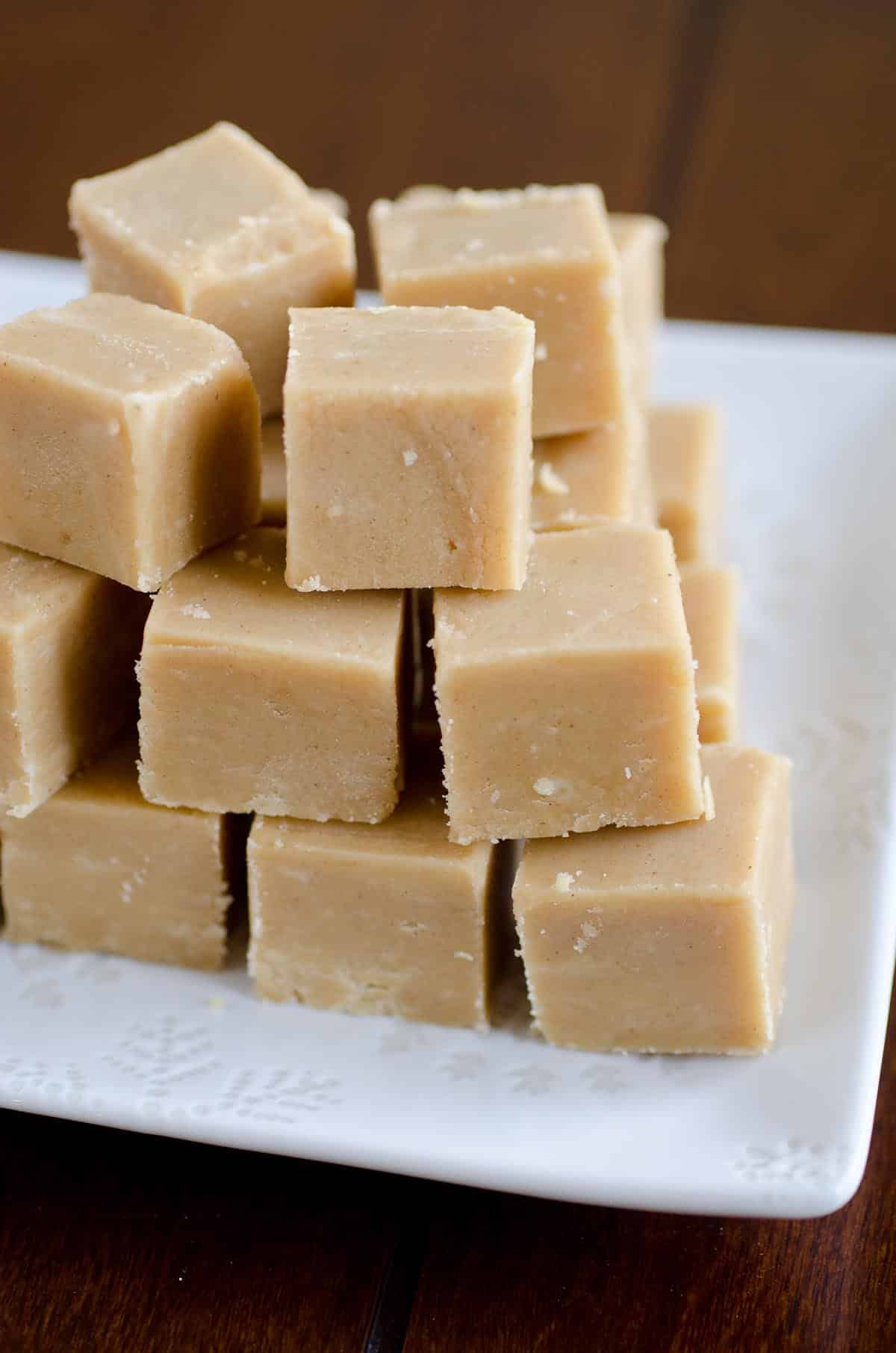 peanut butter fudge squares stacked on a white plate