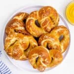 plate of salted soft pretzels with a side of yellow mustard