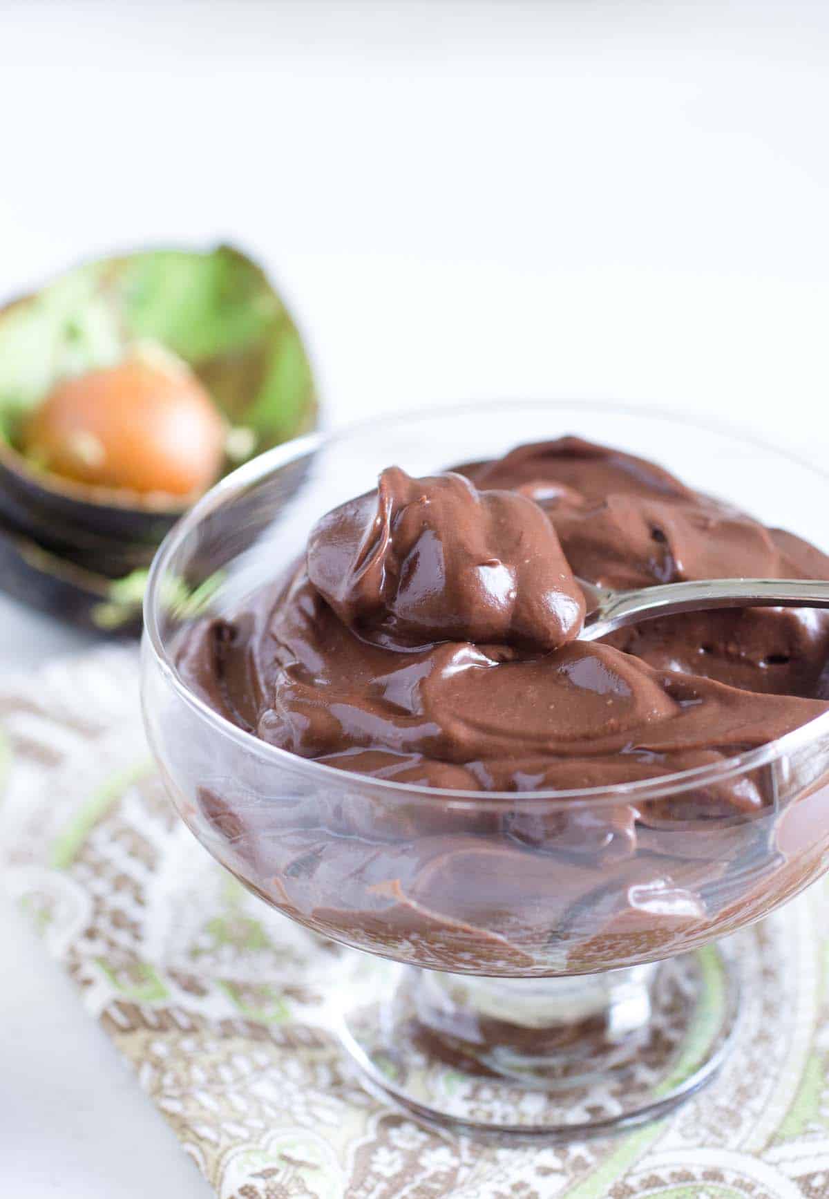 bowl of creamy chocolate pudding with avocado in the back