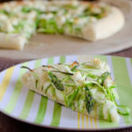 slice of pizza topped with shaved asparagus