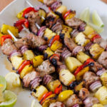 pork and pineapple kebabs on a large platter