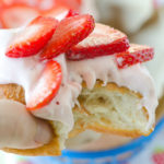 fluffy strawberry donut with topped with strawberry icing and strawberry slices