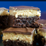 These Buckeye Brownies feature fudge brownie as the base, layered with a traditional peanut butter Buckeye filling and a smooth chocolate topping.
