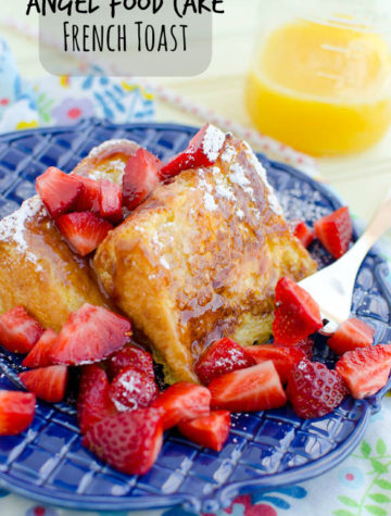 Slices of Angel Food Cake French Toast with strawberries and styrup on a blue plate.