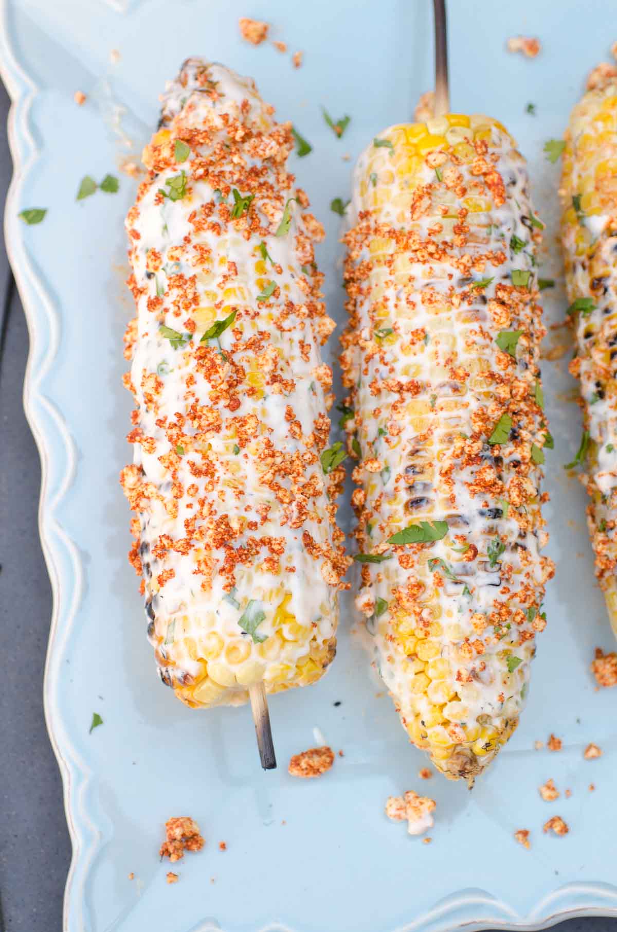 creamy grilled corn on cob on blue plate