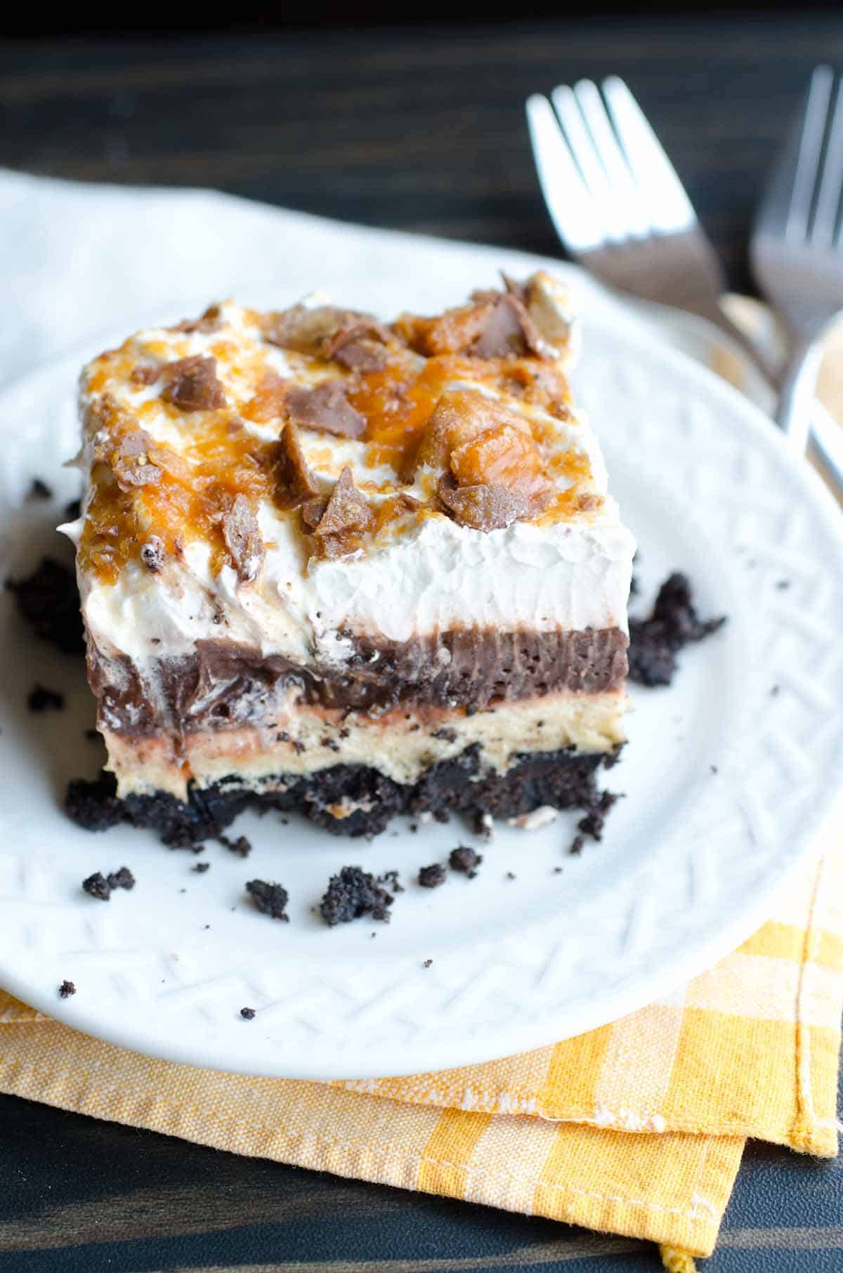 layered chocolate pudding dessert with oreo crust and crushed butterfinger candy bars