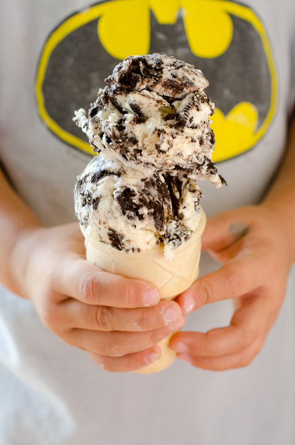 Child hands holding OREO ice cream cone with batman logo in background