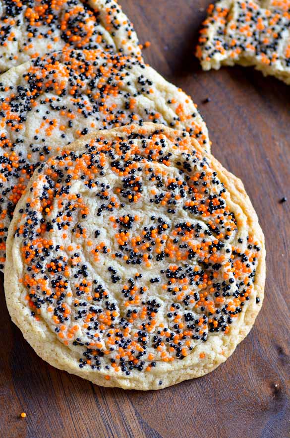 Three giant round sugar cookies with halloween colored sprinkles.