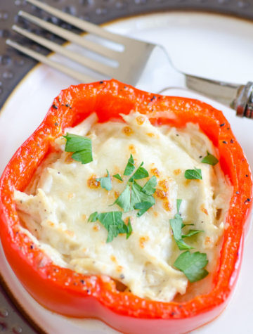 Cheese filled red pepper ring on a plate with a fork.