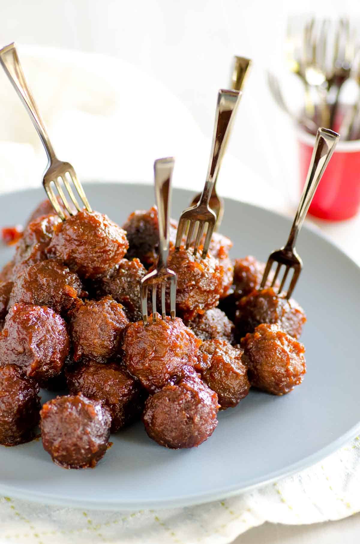 plate full of sweet and sour meatballs with forks