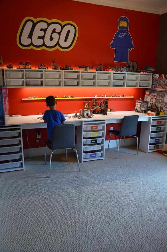 Child sitting and building LEGO set in his LEGO room