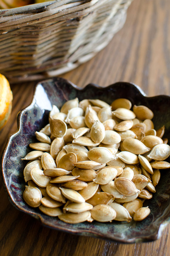 Small pottery bowl of roasted pumpkin seeds.