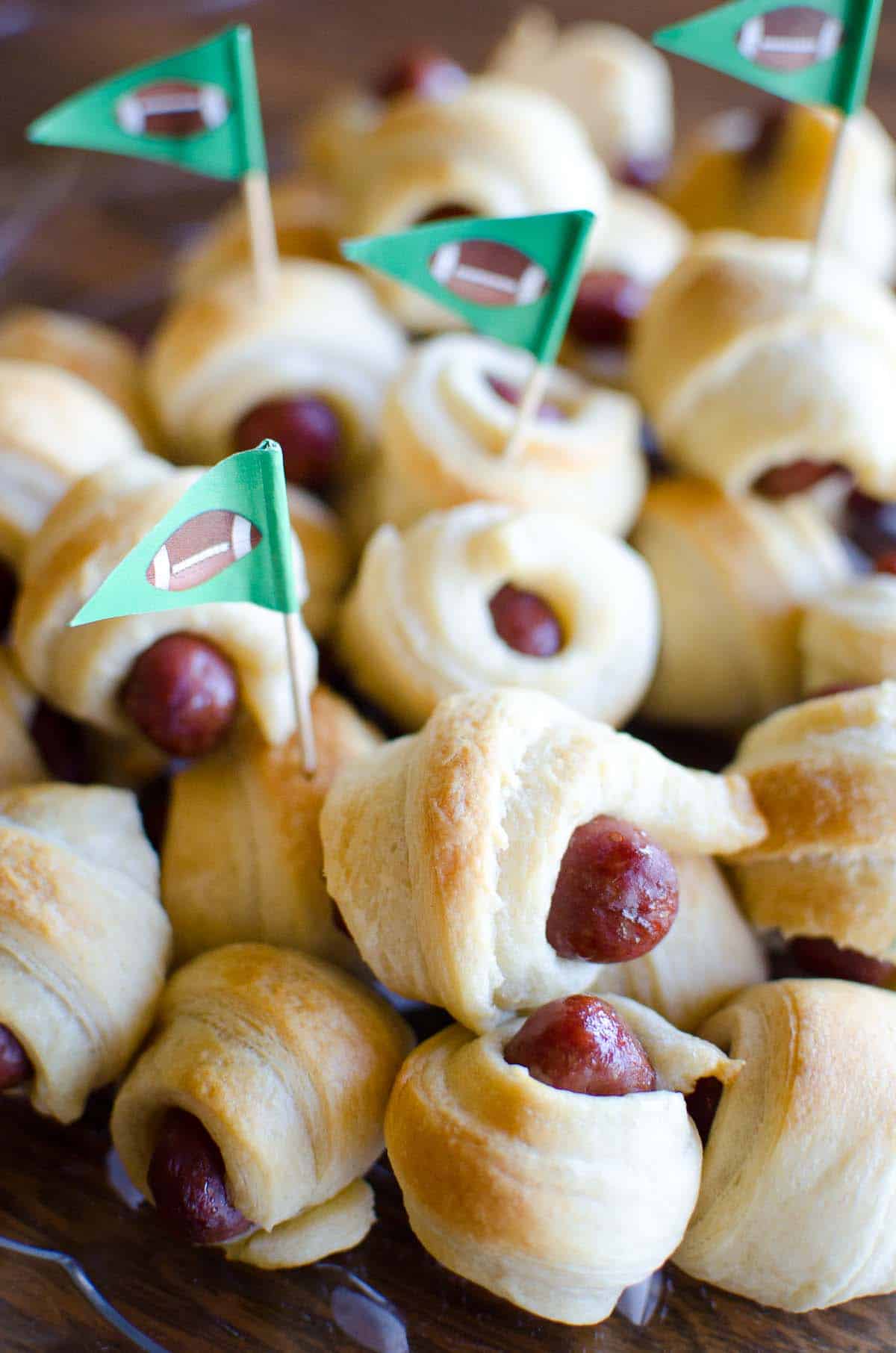 mini pigs in a blanket stacked on a serving platter