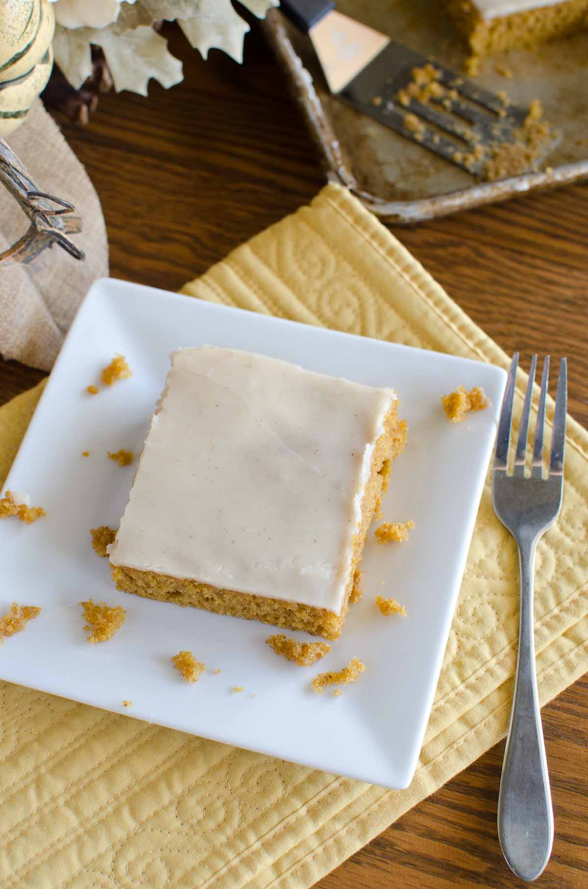 square slice of pumpkin cake with fork on white plate