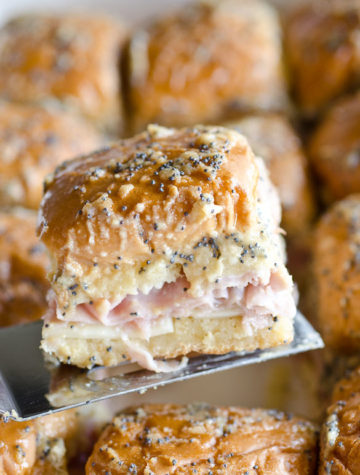 Baked Hawaiian Roll Ham and Cheese Sliders - These ham and cheese sandwiches are baked in Hawaiian rolls with a buttery mustard poppy seed topping. They are a classic party appetizer, but my family eats them for lunch and dinner, too! Serve these ham and cheese sliders right from the oven to the table!