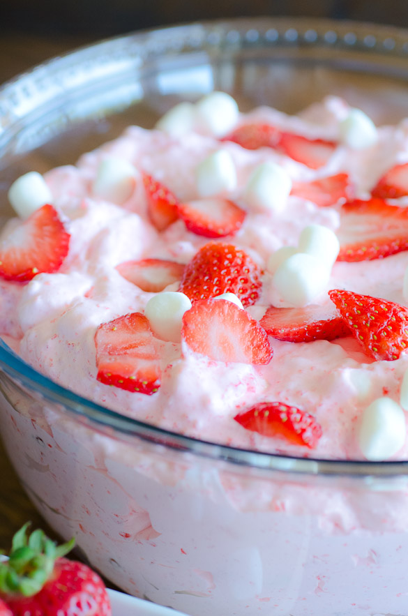 Every party, holiday or potluck meal needs this Strawberry Jell-O Fluff Salad recipe at the table. This whipped Jell-O fruit salad includes Cool Whip and fruit, and can be served as dessert or a side dish. Strawberry Jell-O Fluff Salad gives a perfect fruity fluffy delicious bite!