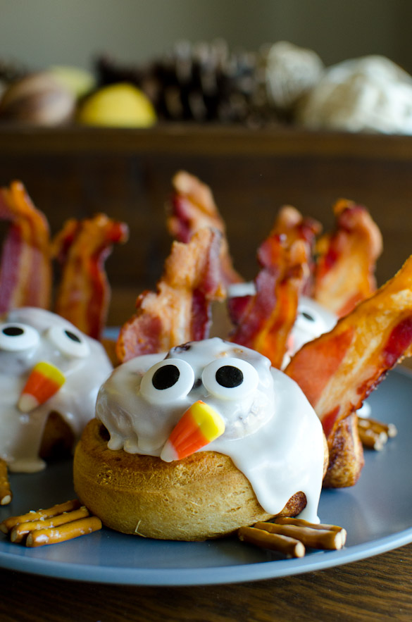 Make a fun Thanksgiving breakfast with these easy Cinnamon Roll Turkeys. Refrigerated cinnamon rolls are quickly baked and then decorated like turkeys with bacon feathers, candy eyes, candy corn nose, and pretzel sticks feet. Your kids will giggle with these goofy cinnamon roll turkeys!