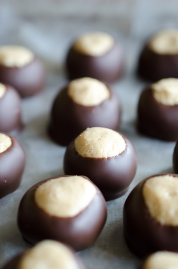 This simple Peanut Butter Buckeyes recipe is a classic no-bake Christmas candy that can be enjoyed year-round. These chocolate-dipped peanut butter balls are rich and creamy and easy to make at home! Keep the buckeyes in the freezer to make them last even longer!
