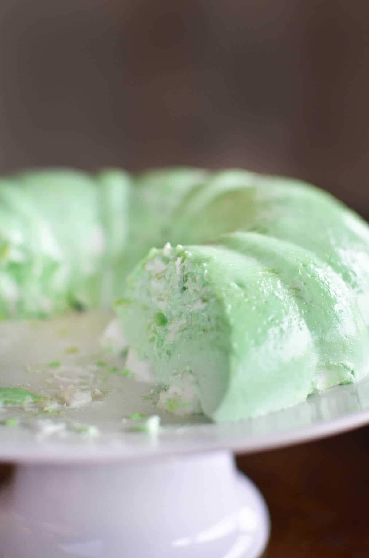 lime green jello mold on white cake pedestal