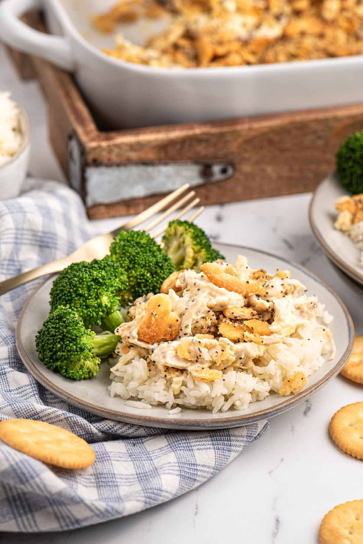 a serving of poppy seed chicken on a plate with broccoli