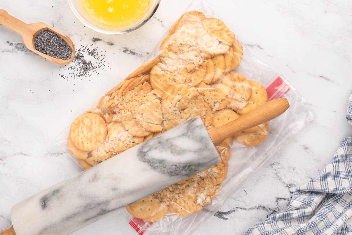crushing Ritz crackers in a plastic bag with a rolling pin