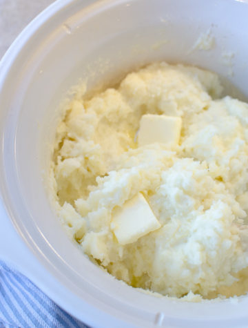 Slow Cooker Mashed Potatoes are creamy, buttery and delicious! Easy prep and little work gets the job done with these velvety rich mashed potatoes. No boiling required, just chop, mash and season for the best fluffy Slow Cooker Mashed Potatoes!