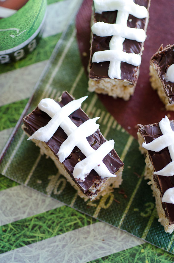 With just a few ingredients you can make these Football Chex Cereal Treat Bars for game day. Melted marshmallows are mixed with Chex cereal and topped with a simple melted chocolate. Use white icing to pipe on the football stripes to complete the decoration!