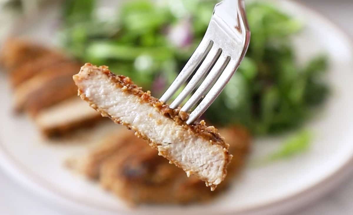 slice of pork held with fork
