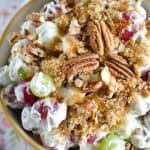 grape salad in a bowl topped with brown sugar and pecans