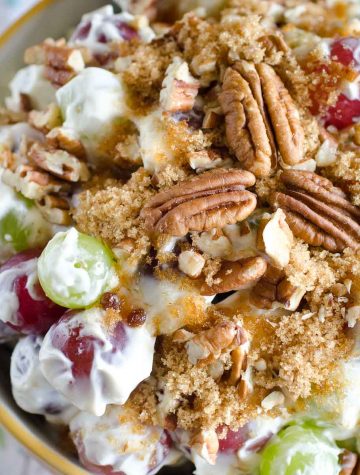 grape salad in a bowl topped with brown sugar and pecans