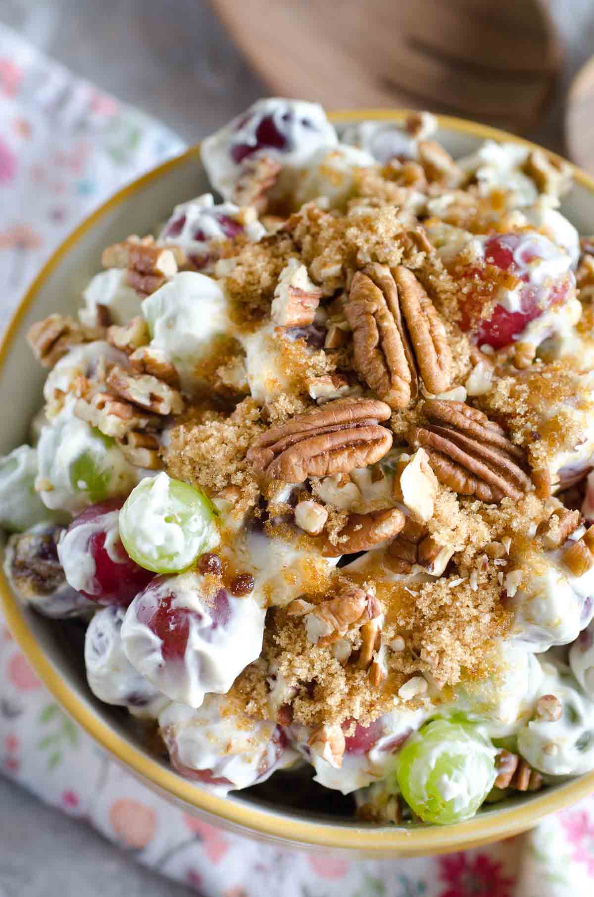 bowl of grape salad topped with sugar and pecans