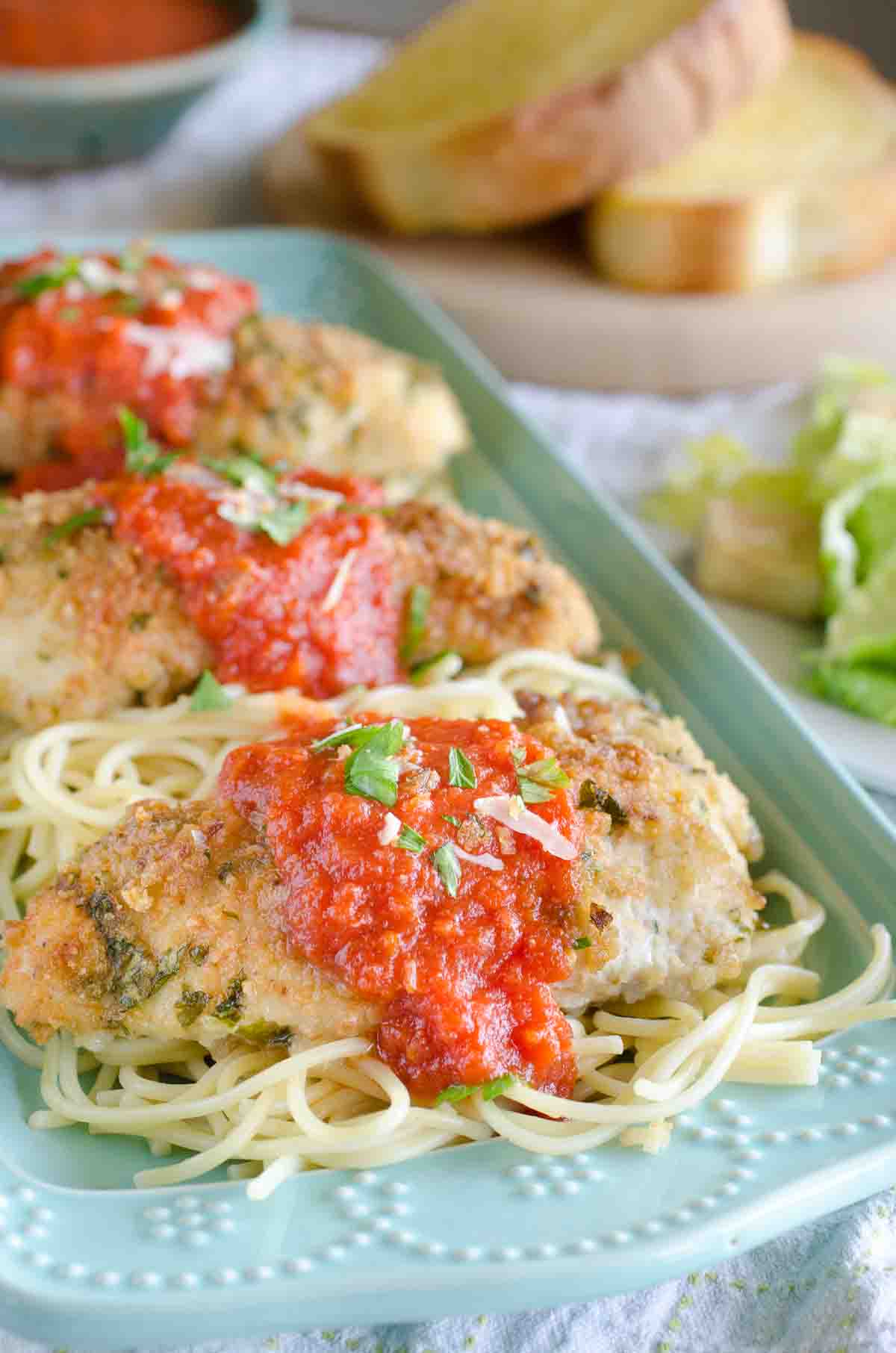 chicken parmesan topped with marinara over spaghetti noodles