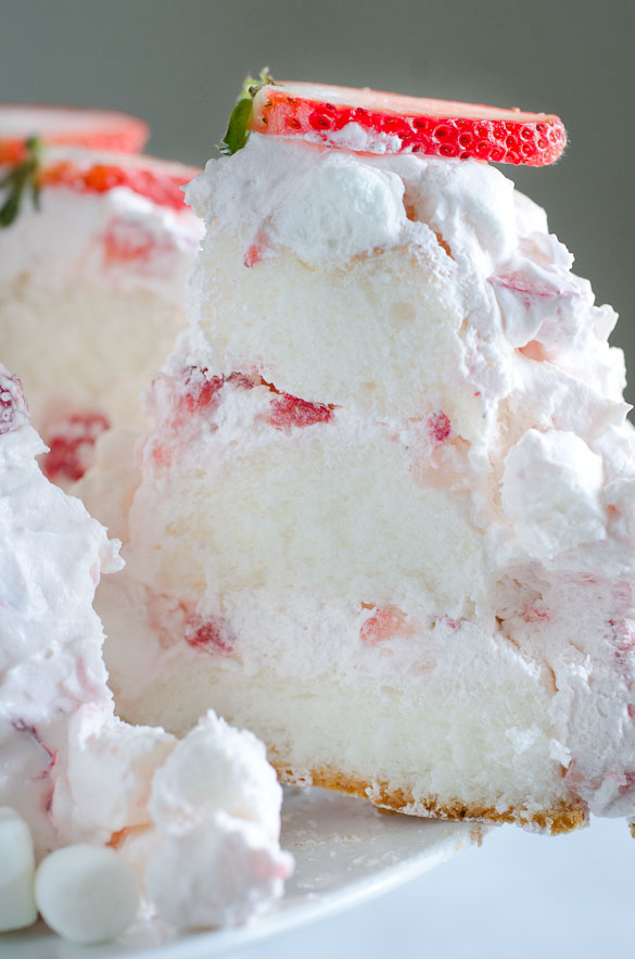 Slice of layered angel food cake with strawberry marshmallow frosting.
