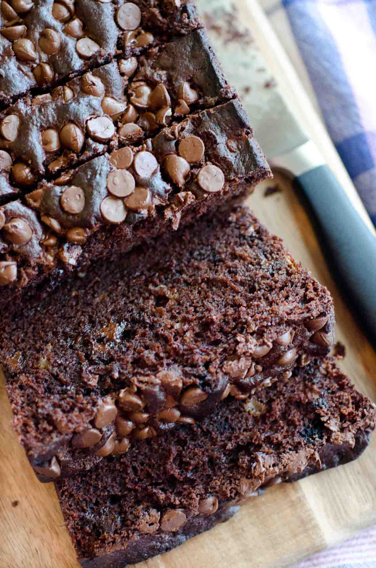 sliced loaf of chocolate banana bread on cutting board with knife