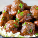 Sweet and sour meatballs stacked in a skillet with cauliflower rice