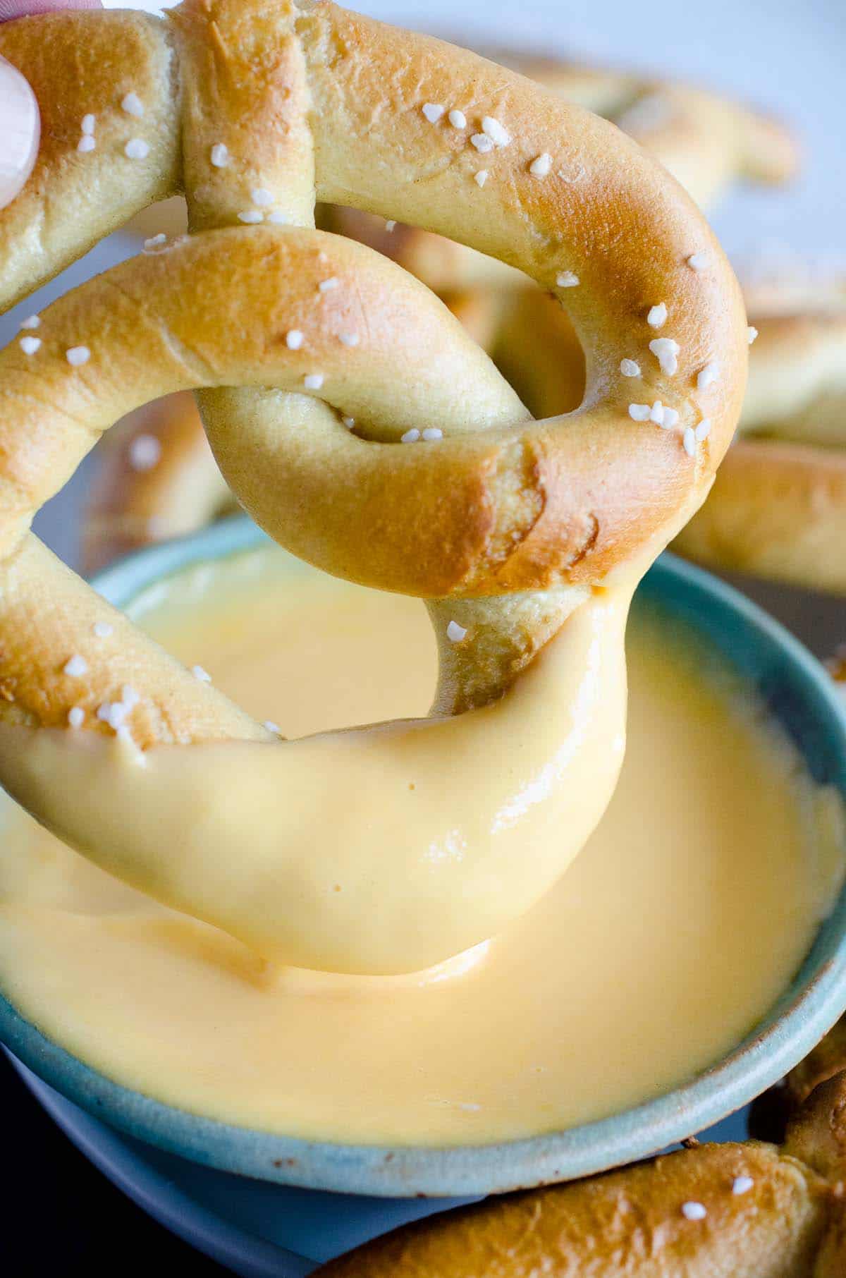 soft pretzel dipped in bowl of beer cheese