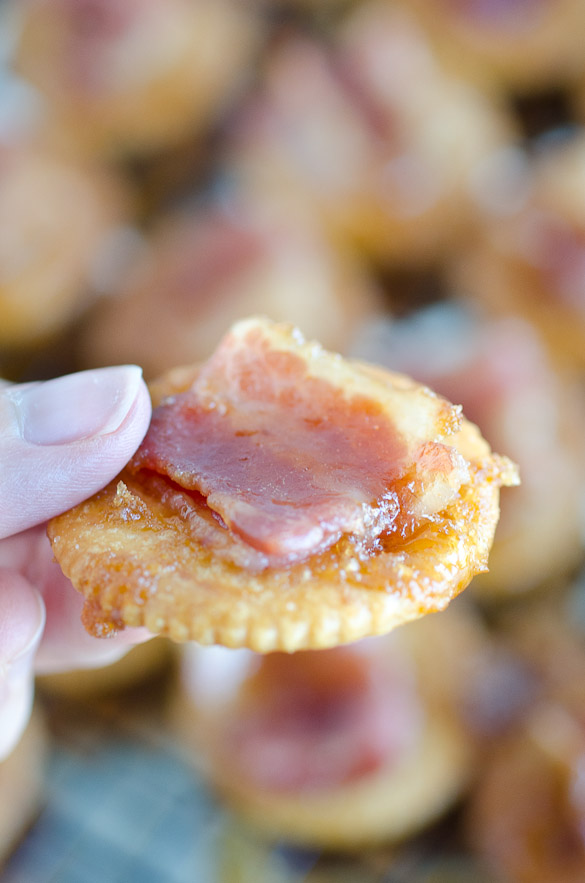 Hand holding a candied bacon Ritz cracker