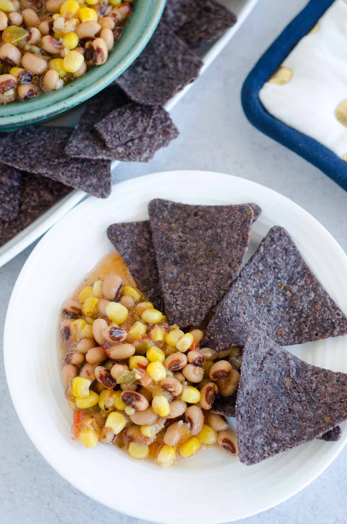blue corn chips on a plate with black eyed peas