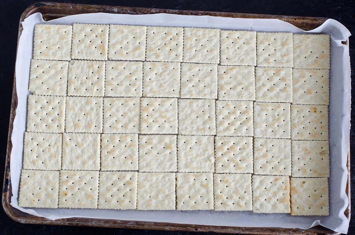 saltine crackers lined in a rimmed baking sheet